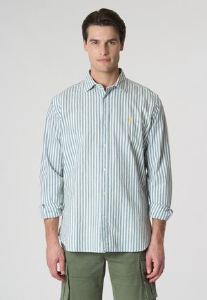 Camicia a maniche lunghe a strisce verdi e bianche, design con bottoni sul davanti, con un piccolo logo giallo sul petto, realizzata in tessuto leggero.