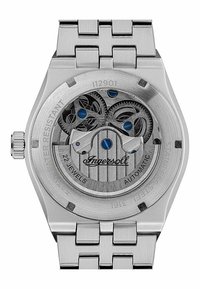 Montre-bracelet en acier inoxydable avec mouvement automatique ; le fond de boîtier transparent révèle des engrenages complexes ; présente des accents bleus et un logo texturé.