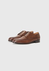 Chaussures habillées en cuir marron avec un bout arrondi, un laçage et une texture lisse. Présentent des détails de couture subtils et un petit talon.