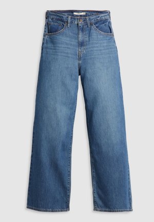 Jean en denim bleu clair avec un design à jambes larges, cinq poches et une fermeture à bouton. Présente des coutures piquées et une texture légèrement décolorée.