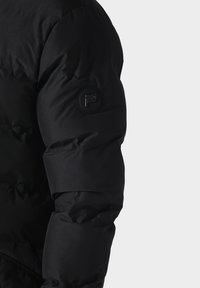 Zwarte donzen jas met een getextureerd oppervlak en gewatteerd ontwerp. Heeft een ronde logo patch op de linkermouw.