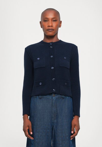 Marineblauwe geribde cardigan met een ronde hals en sluiting met knopen aan de voorkant. Bevat twee borstzakken en contrasterende knoopaccenten.