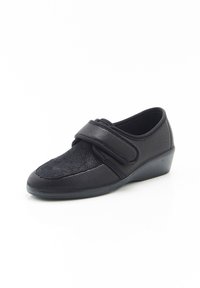 Scarpa nera con fascia in Velcro, superiore in tessuto a rete testurizzata e tessuto liscio, punta arrotondata, tacco basso a zeppa e suola in gomma flessibile.