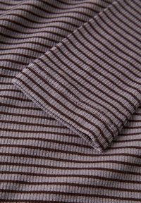 Close-up van gevouwen ribbelstof met smalle horizontale bruine en grijze strepen.