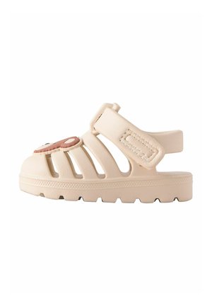 Beige Kindersandale mit verstellbarem Riemen und Cartoon-Bärengesicht-Dekoration auf dem geschlossenen Vorderteil, strukturierte Sohle für besseren Halt.