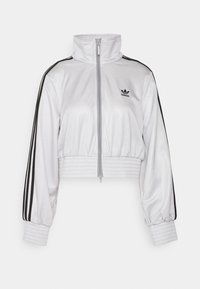 White zip-up jacket with a high collar, black stripes on sleeves, and elasticized hem and cuffs. Features the Adidas logo on the chest.