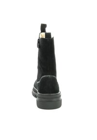 Bottine en suédine noire avec une texture lisse, fermeture éclair à l'arrière et semelle en caoutchouc épaisse. Dispose d'une languette à l'arrière pour un enfilage facile.