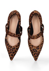 Chaussures à bout pointu en imprimé léopard avec une texture en fourrure, des accents noirs et des doubles sangles sur les côtés. Doublure intérieure beige douce.