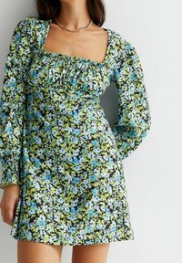 Blommig klänning med fyrkantig halsringning, puffiga långa ärmar, svart bakgrund med blå och gröna blommor samt elastiska detaljer vid bysten.