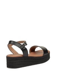 Las sandalias de plataforma negras cuentan con correas sintéticas texturizadas, diseño de punta abierta, correa ajustable en el tobillo y una plantilla acolchada color beige.