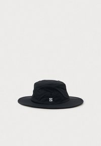 Chapéu de balde preto de aba larga com um "S" branco bordado na frente, feito de tecido leve, exibido sobre um fundo claro e neutro.
