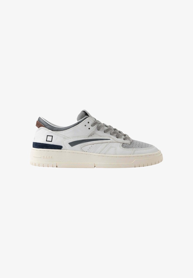 Sneaker bassi bianchi e grigi con lacci grigi, punta perforata, accento nero e suola beige con il nome del marchio sul tallone.
