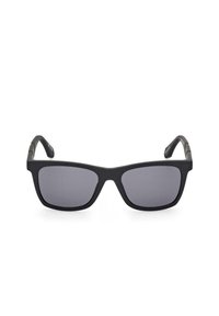 Occhiali da sole neri a forma quadrata con lenti grigie, montatura opaca e accenti metallici sulle aste. Il design presenta una forma classica con tempie larghe.