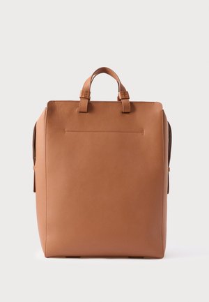 Rektangulær rygsæk i tanfarvet læder med topgreb og minimal syning, set forfra mod en ensfarvet baggrund.