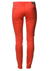 Chude dżinsy w jasnym koralowym kolorze, wykonane z gładkiego denimu. Posiadają dwie tylne kieszenie oraz czysty pas z małą metką marki z tyłu.