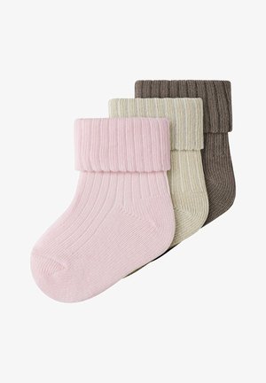 Drie paar geribbelde gebreide babysokjes met omgeslagen boord in roze, crème en bruin, overlappend gestapeld op een witte achtergrond.