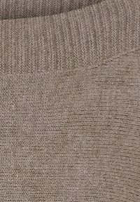Striktrøje i taupe, med ribbet udskæring og tekstureret stof, der har en blød, let fuzzy overflade.