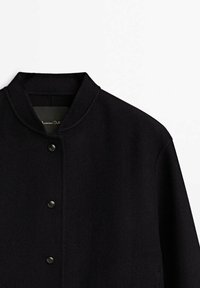 Black wool blend jacket with a mandarin collar, featuring a button placket and smooth texture. No visible patterns or accents.