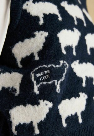 Marineblauer Wollpullover mit weißen Schafmustern und dem auf einem Schaf gestickten Spruch "WHAT THE FLOCK". Weicher Stoff, lässiges Design.