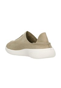 Beige Wildlederschlupfschuh mit weißer strukturierter Sohle, niedrigem Absatz und abgerundeter Zehenpartie, von der Seite und leicht schräg von hinten gezeigt.