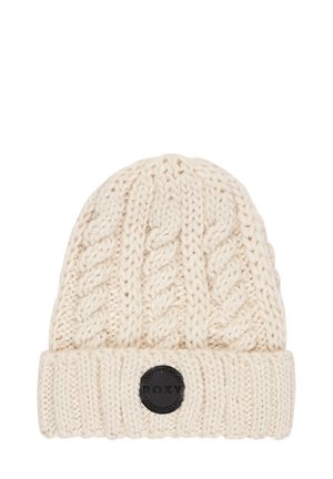 White knitted beanie with a textured cable pattern, featuring a ribbed cuff and a black circular logo patch labeled "Roxy."