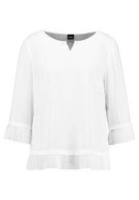 Valkoinen pusero, jossa on V-pääntie, koristeelliset napit kaulassa ja kolmannes pitkät hihat, joissa on poimutetut yksityiskohdat hihoissa ja helmassa.