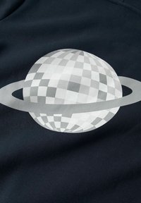 Sfera bianca e grigia a scacchi con un anello orizzontale attorno al centro su uno sfondo di tessuto nero.
