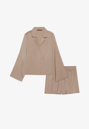 Vaalean beige satiininen yöasu, jossa on lyhythihainen napillinen paita, jossa on lovet kaulus, ja löysät shortsit, joissa on joustava vyötärö.