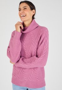 Maglione rosa a maglia con collo a cappa, caratterizzato da un motivo a trecce texturizzato e dettagli a coste sul colletto e sulle maniche.