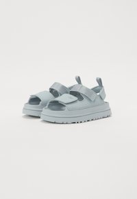 Lys blå sandaler med åpne tær, justerbare stropper og teksturerte såler. Laget av syntetisk materiale med en tykk plattformdesign.