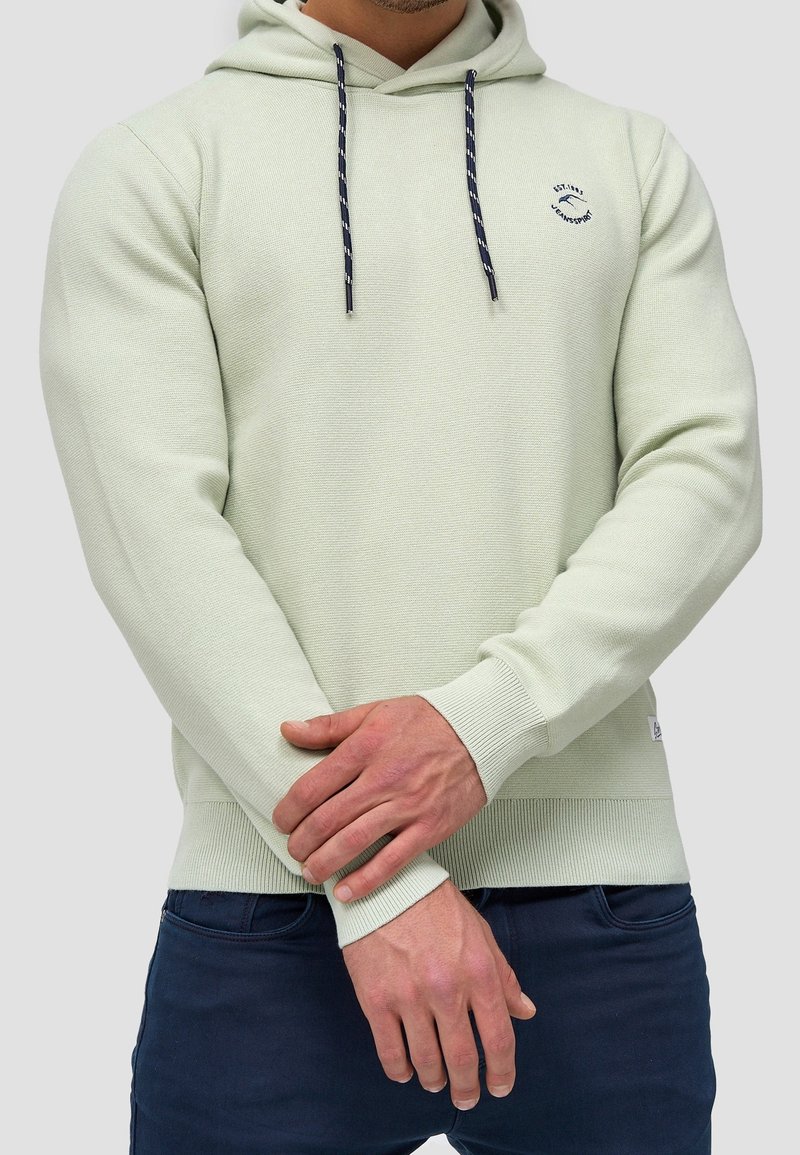 Sudadera con capucha verde claro de tejido texturizado, con un pequeño logo, cordones en azul marino y puños y dobladillo acanalados.