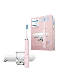 Brosse à dents électrique rose avec une tête de brosse ronde bleu et blanc, support en verre, étui de chargement blanc et emballage comportant la marque et les instructions d'utilisation.