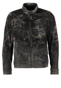 Svart denimjacka med en urblekt, sliten textur. Har hög krage, frontdragkedja och två bröstfickor med lock och dragkedjor.