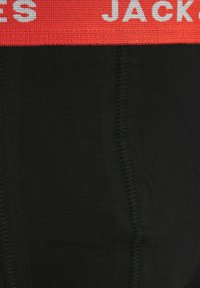Boxers en coton noirs avec une ceinture élastique rouge portant l'inscription "JACK" en blanc, mettant en valeur une texture lisse et un ajustement confortable.