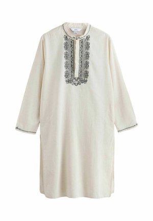 Dolga kremna tunika s črnim zapletenim vezenjem okoli izreza in manšet, z razcepljenim ovratnikom in dolgimi rokavi.