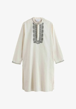 Dolga kremna tunika s črnim zapletenim vezenjem okoli izreza in manšet, z razcepljenim ovratnikom in dolgimi rokavi.