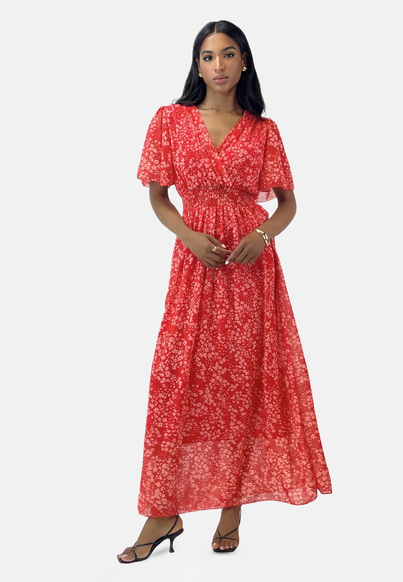 Red floral maxi dress with a v-neck, short flutter sleeves, and a smocked waist. Lightweight fabric, flowing texture, and sheer finish.