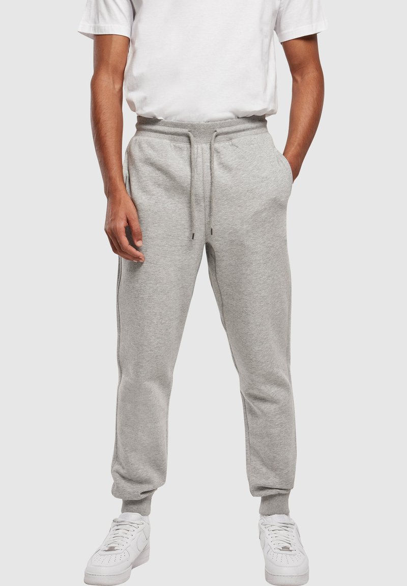 Gray sweatpants made of cotton blend fabric, featuring an elastic waistband with drawstring and cuffed ankles, styled with side pockets.