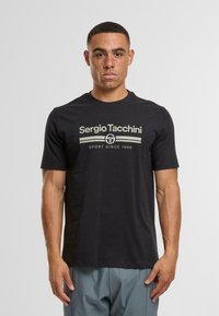 Černé bavlněné tričko s bílým a béžovým logem Sergio Tacchini na hrudi. Krátké rukávy a kulatý výstřih.