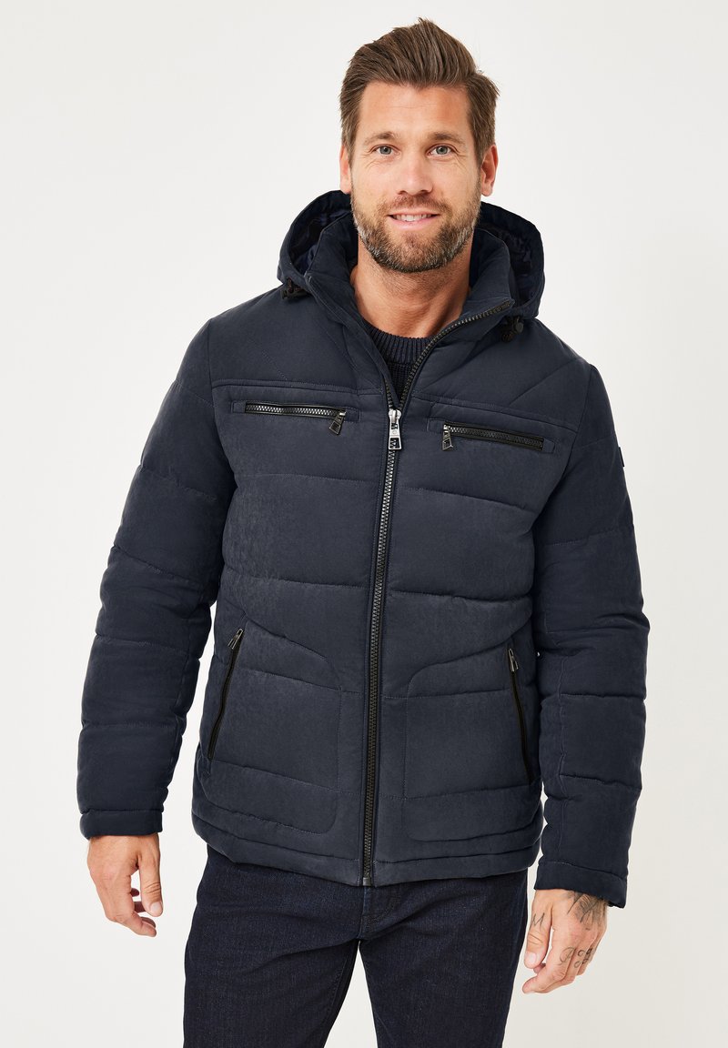 Marineblaues Puffer-Jackett mit Reißverschlussfront, Kapuze und mehreren Reißverschlusstaschen. Mit gestepptem Design und weichem Material.