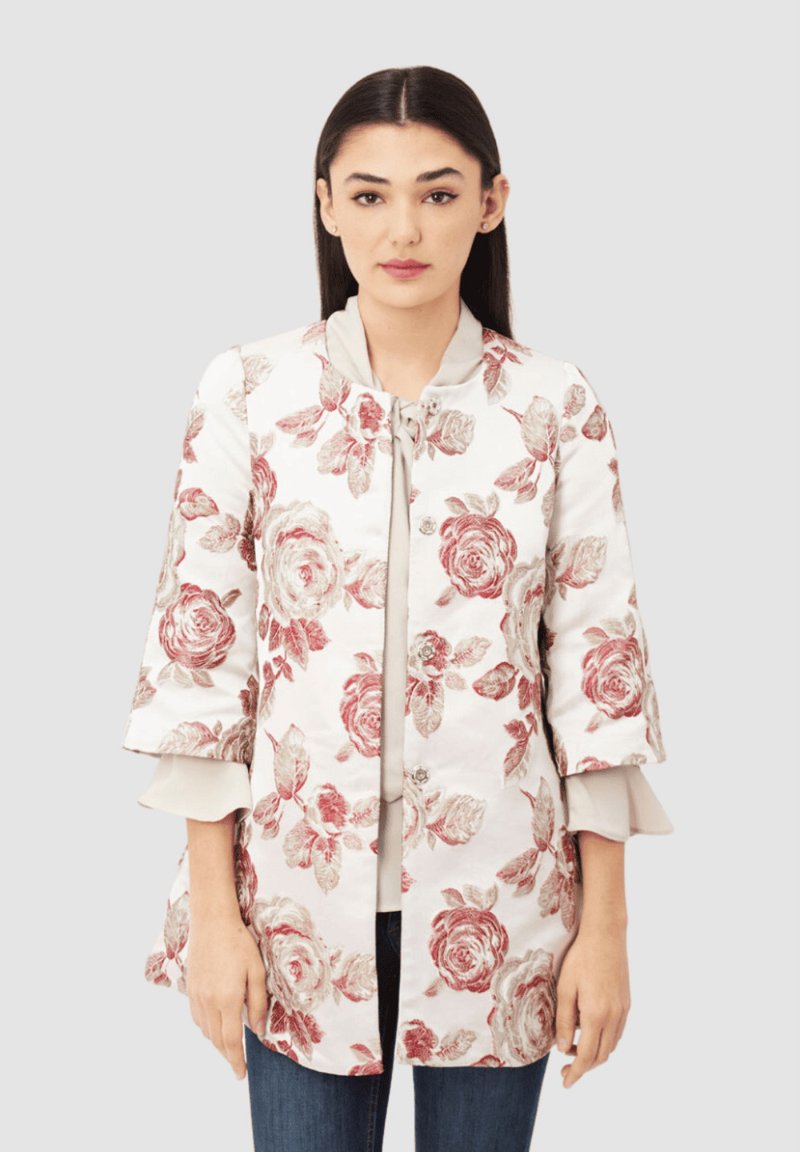 Chaqueta bordada floral en blanco con patrones de rosas rojas, que presenta un escote redondo, cinta de lazo y mangas acampanadas de tres cuartos.