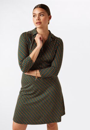 Grünes gemustertes Kleid mit 3/4-Ärmeln, das ein geometrisches Design in Orange und Blau aufweist, aus einem glatten, leichten Stoff gefertigt.
