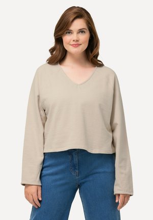 Beige lange mouw top met een V-hals en een relaxte pasvorm. Gemaakt van een textuurmateriaal, heeft het een cropped ontwerp en brede mouwen.