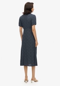 Granatowa kwiatowa sukienka midi z krótkimi rękawami, dopasowanym góra i rozkloszowaną spódnicą; lekka tkanina z drobnymi białymi wzorami.