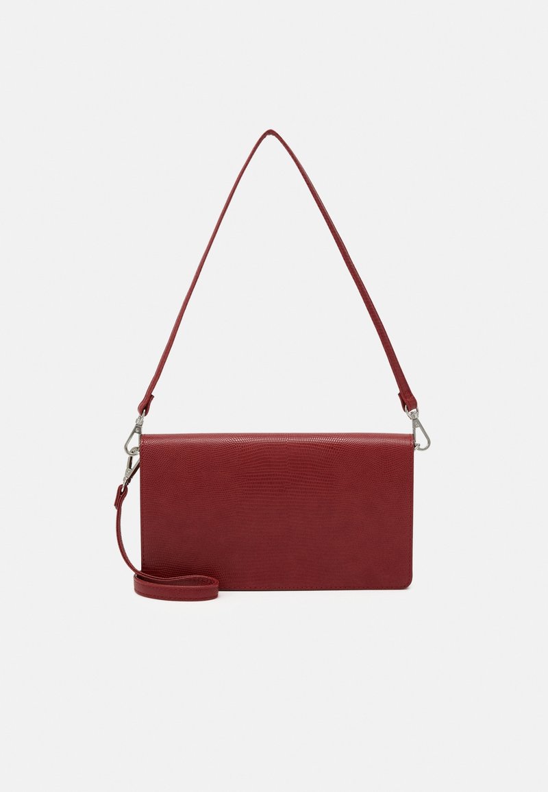 Bolso de mano rojo con textura, correa larga y herrajes plateados. Forma rectangular con un acabado suave y un patrón sutil en relieve.