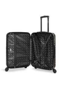 Valise rigide noire avec poignée extensible, quatre roues, ouverte pour montrer les compartiments intérieurs et les sangles croisées pour sécuriser le contenu.