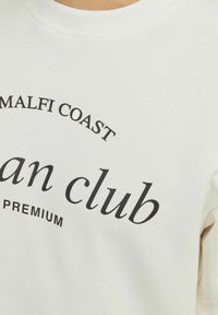 Felpa bianca con testo nero che recita "AMALFI COAST" e "urban club PREMIUM." Tessuto morbido con un classico design a girocollo.
