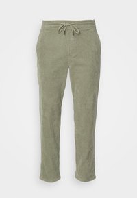 Pantalon en velours côtelé vert clair avec taille élastique et cordon de serrage, coupe droite et poches latérales, présenté sur un fond blanc.