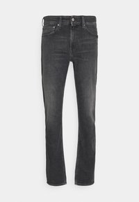 Svarta denimjeans med slim fit, femfickorsdesign och subtil blekning. Har en knappstängning och kontrasterande sömmar längs sömmarna.