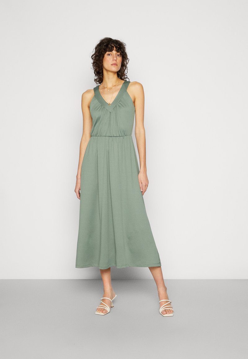 Vestido maxi em tecido verde-sálvia com decote em V e detalhe na cintura franzido, apresentando uma silhueta fluida e design minimalista.